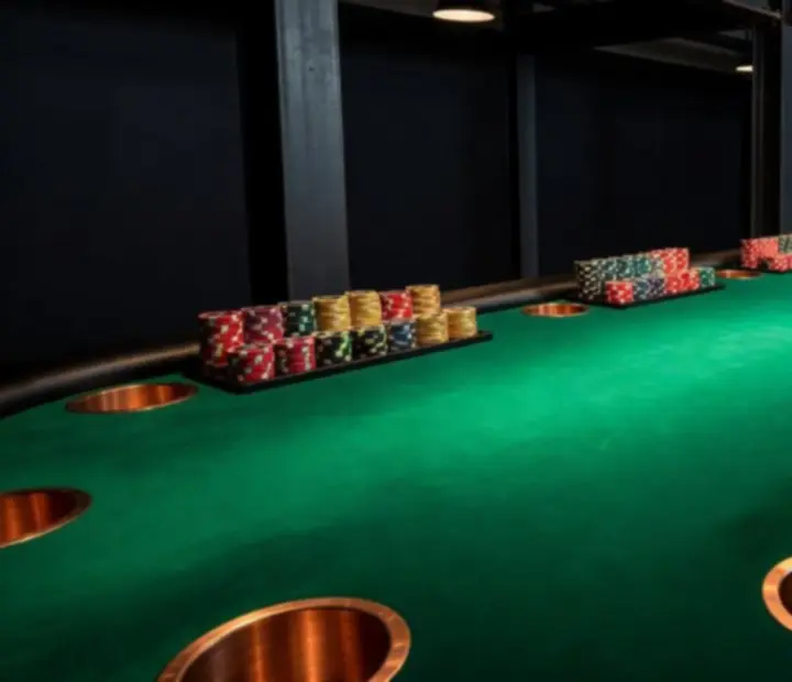 Custom poker felt table with copper inlays and neatly stacked collectible poker chips